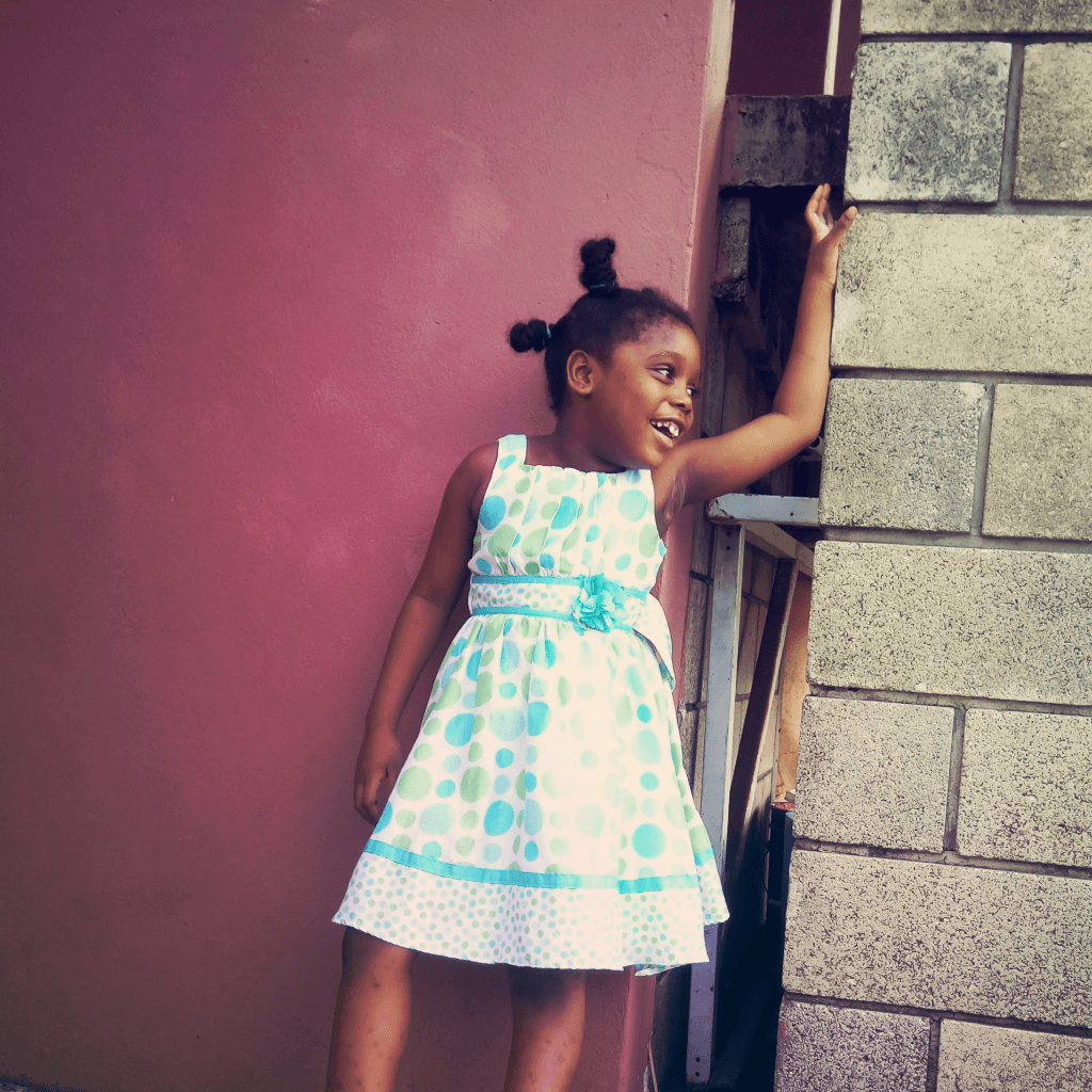 My niece posing next to a wall.